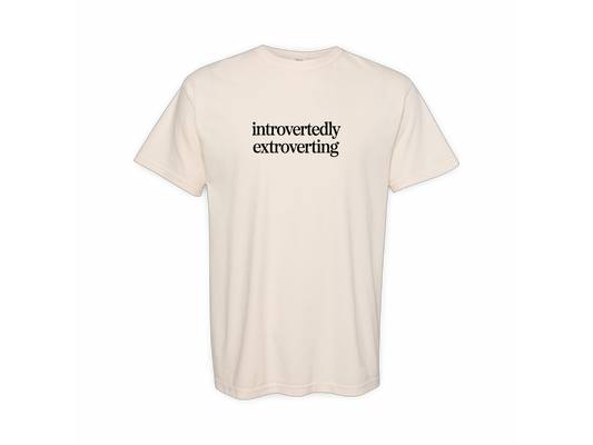 Beige t-shirt with 'introvertly extroverting' text on a white background
