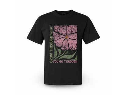 The JT way Grow T-shirt in black with white text, featuring a casual fit and round neckline, displayed on a hanger.